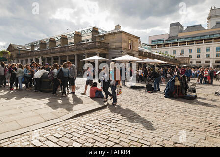 LONDON, Regno Unito - 5 giugno 2014: folle raccogliere su una soleggiata giornata di primavera in Covent Garden come gli artisti di strada esibirsi in Foto Stock