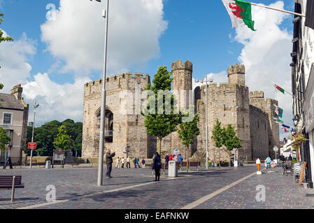 CAERNARFON, Regno Unito - 8 giugno 2014: turisti nella piazza principale di Caernarfon, Galles durante un ventoso mattina di primavera Foto Stock