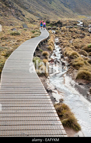 Giovane camminando sulla pubblica via al parco nazionale di Tongariro, Nuova Zelanda Foto Stock