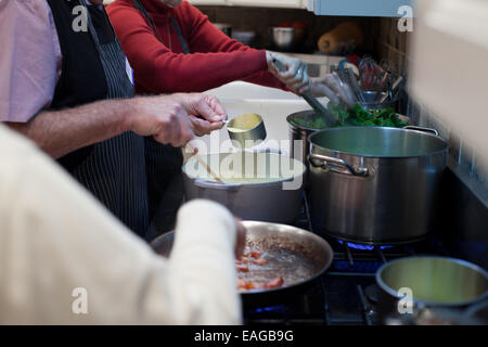 Mani occupato preparandosi un pasto in cucina Foto Stock
