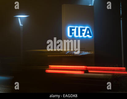 Zurigo, Svizzera. 14 Novembre, 2014. Un auto è passando dall'ingresso illuminato segno della FIFA presso la sede centrale sul buio "FIFA Street' di Zurigo, Svizzera. Credito: Erik Tham/Alamy Live News Foto Stock