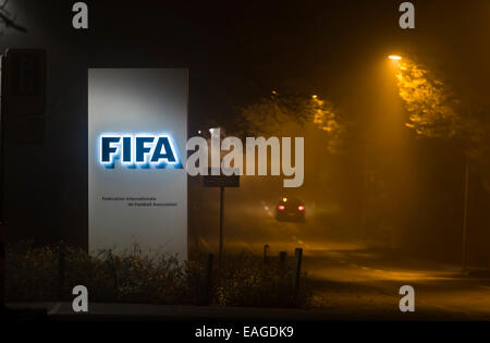 Zurigo, Svizzera. 14 Novembre, 2014. Mentre si guida verso il basso il vicolo buio di "FIFA Street', una vettura sta passando dall'ingresso illuminato segno della FIFA sede a Zurigo, Svizzera. Credito: Erik Tham/Alamy Live News Foto Stock