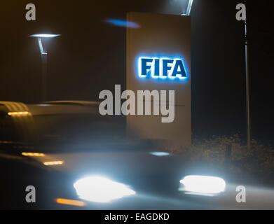 Zurigo, Svizzera. 14 Novembre, 2014. Un auto è passando dall'ingresso illuminato segno della FIFA presso la sede centrale sul buio "FIFA Street' di Zurigo, Svizzera. Credito: Erik Tham/Alamy Live News Foto Stock