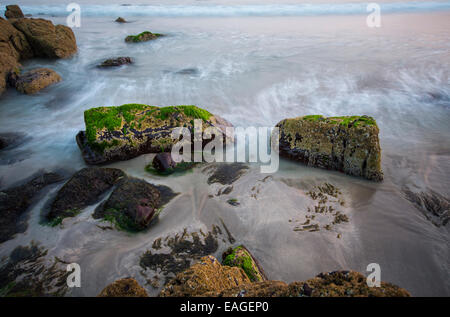 Le rocce su una spiaggia esposta dal mare con la bassa marea Foto Stock