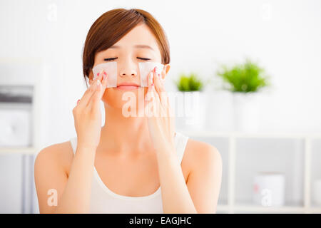 Bella giovane donna pulizia viso con cotone Foto Stock