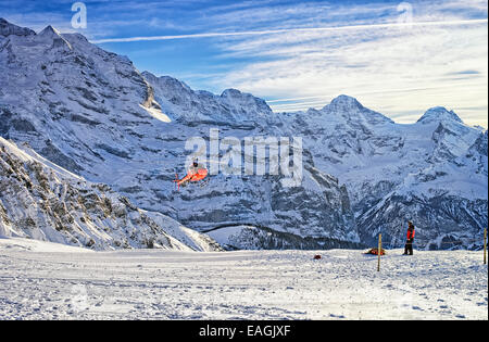 Red elicottero sorvolano swiss ski resort vicino monte Jungfrau Foto Stock