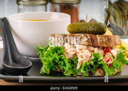 Insalata di tonno sandwich con lattuga su segale tostato con la zucca zuppa, patatine fritte e sottaceti Foto Stock