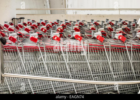 Una fila di carrelli di shopping nella parte anteriore di un supermercato Foto Stock