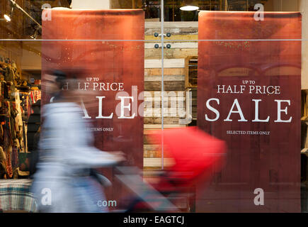 Vendita sign Shoppers godendo i vari sconti e offerte di vendita nei negozi lungo Market Street, Manchester, Regno Unito Foto Stock