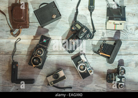 Set di vintage e nuove telecamere su sfondo di legno Foto Stock