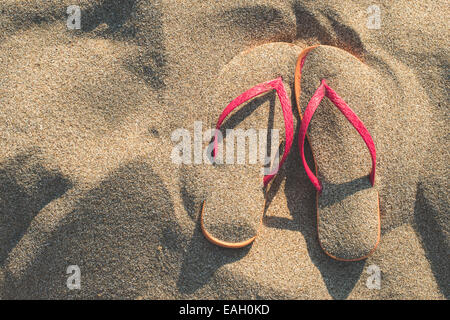 Sandali rosa sulla spiaggia in sabbia Foto Stock