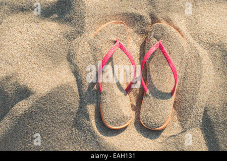 Sandali rosa sulla spiaggia in sabbia Foto Stock