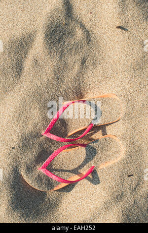 Sandali rosa sulla spiaggia in sabbia Foto Stock