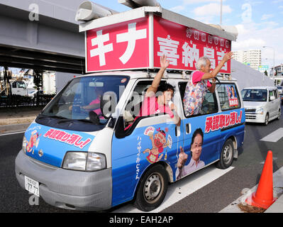 Naha, Giappone. Xv Nov, 2014. Shoukichi Kina, un candidato per il governatore della prefettura di Okinawa, onde la sua mano per appello agli elettori per le prossime elezioni del 9 novembre 16 a Naha, la capitale di Okinawa, in Giappone, il 9 novembre 15, 2014. © Stringer/Xinhua/Alamy Live News Foto Stock