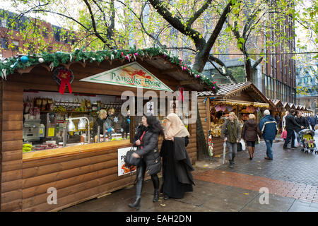 Commercianti di mercato Manchester UK, 14 novembre 2014. Giorno di apertura dei mercatini di Natale che attirano acquirenti dal Regno Unito e oltre. Le bancarelle, gli chalet e i chioschi festosi del centro della città sono diventati un luogo favoloso dove fare shopping e sono una destinazione turistica molto popolare a se stante. Si suggerisce che l'inverno mancuniano sia completo senza una passeggiata attraverso le strade dei mercati fiancheggiate da chalet, un esempio della strategia DI OFFERTA al lavoro per la rigenerazione del centro cittadino pedonalizzato. Foto Stock