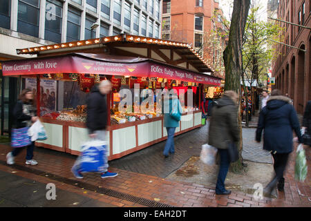 I rivenditori di dolciumi scelgono e mescolano dolciumi per le feste, cioccolato e dolci. Un'affollata selezione di dolciumi. Fai un mix di barattoli dolci e fudge store, parte del mercatino di Natale di Liverpool a St George's Place, Liverpool, Regno Unito Foto Stock