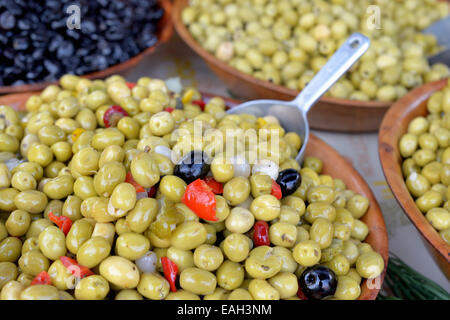 Diversi tipi di olive marinate con spezie ed erbe aromatiche in vendita sul mercato di villaggio Foto Stock