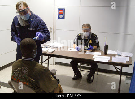 US Coast Guard Tecnico Sanitario Nathan Wallenmeyer e Supervisore di CBP Sam Ko condotta prescreening per Ebola su un passeggero proveniente dalla Sierra Leone in corrispondenza dell'Aeroporto Internazionale O'Hare's terminale 5 Ottobre 16, 2014 in Chicago, IL. Foto Stock