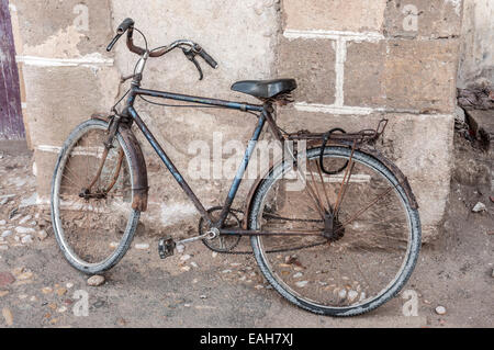 Vecchia bicicletta appoggiata contro il muro in Marocco Foto Stock