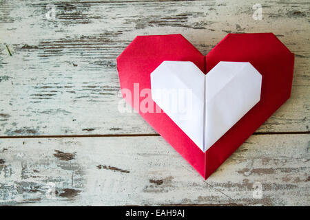 Rosso e bianco cuori origami su bianco tavolo in legno Foto Stock