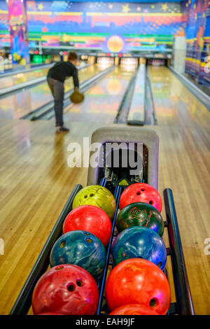 Palle da bowling e silhouette di player su sfondo sfocato Foto Stock