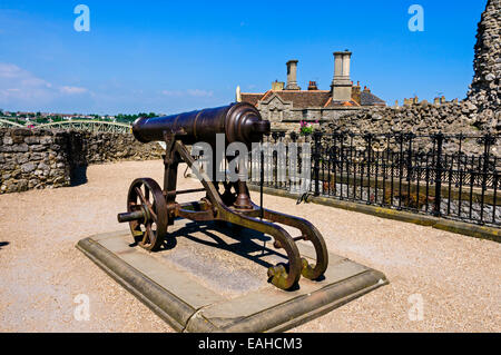 Una ghisa nera cannone montato sul suo carro nel parco del castello di Rochester protetto dalle rovine della cortina. Foto Stock