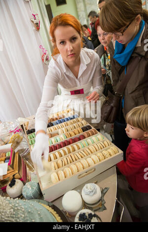 Varsavia, Polonia. 15 Novembre, 2014. Donna vende macaron - Francese meringa dolce-basato confection visualizzata su un supporto durante la International cioccolato e caramelle Festival presso il Palazzo della Cultura e della scienza a Varsavia in Polonia Credito: kpzfoto/Alamy Live News Foto Stock