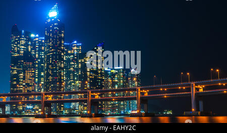 Lo skyline di Busan illuminata di notte, con Gwangan Bridge in primo piano. Foto Stock