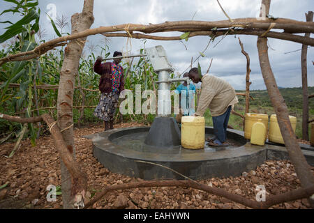 Gli abitanti di un villaggio di attingere acqua da un pozzo nel distretto di Bukwo, Uganda, Africa orientale. Foto Stock