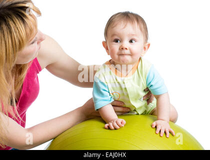 Madre di fare ginnastica con il bambino a montare la sfera Foto Stock