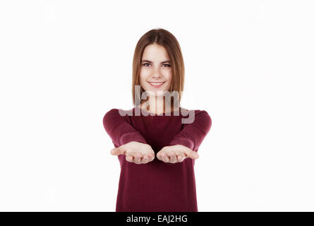 Giovane donna smilling in maglione rosso che offre a voi Foto Stock