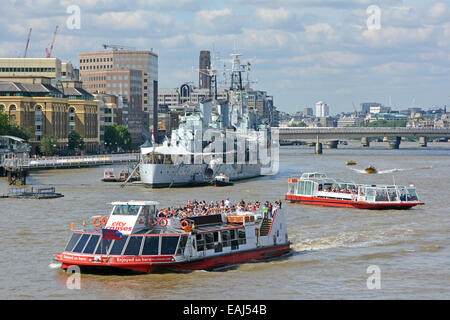 Gita turistica di barche in pool di Londra con HMS Belfast tempo di guerra cruiser ormeggiati nel Tamigi come parte del Museo Imperiale della Guerra Foto Stock