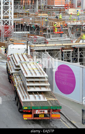 Grande 'Elephant e Castle rigenerazione' firmare sul sito in costruzione palizzata con camion che arrivano con pannelli di pavimentazione Foto Stock