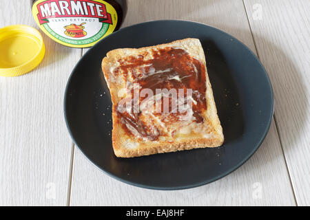 Unico pezzo di pane tostato caldo con burro e marmite Foto Stock