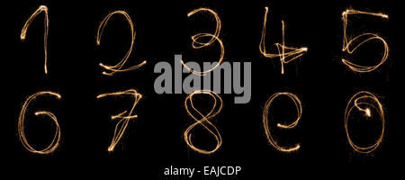 I numeri da 0 a 9 scritta con un sparkler isolati su sfondo nero Foto Stock