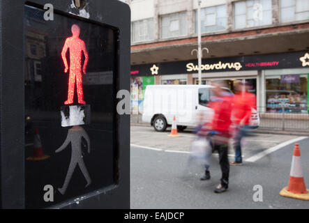 Il movimento sfocati persone attraversando al Pelican crossing Southport, Merseyside, Regno Unito Foto Stock