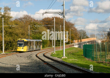 Tram Metrolink avvicinando il fiume Mersey viadotto vicino alla vendita Parco Acquatico stop, linea Aeroporto, Manchester, Inghilterra, Regno Unito Foto Stock