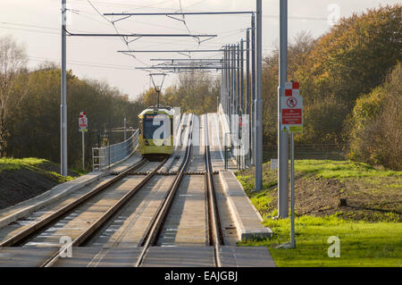 Tram Metrolink avvicinando il fiume Mersey viadotto nei pressi di Hardy Lane, linea Aeroporto, Manchester, Inghilterra, Regno Unito Foto Stock