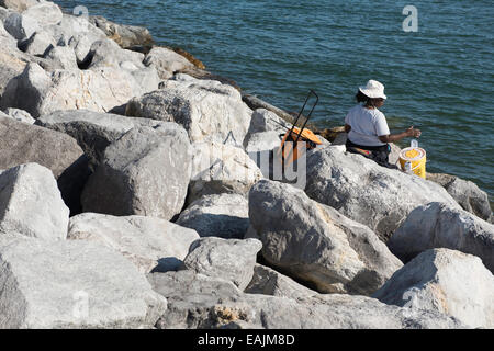 African American donna pesca dal molo Lighthouse Point Park, Volusia County, Florida, U.S.A. Foto Stock