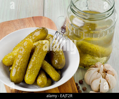 Cetrioli sottaceto in una ciotola e vaso di vetro con aglio. Messa a fuoco selettiva Foto Stock