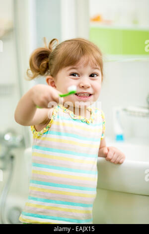 Bambino ragazza spazzolare i denti in bagno Foto Stock