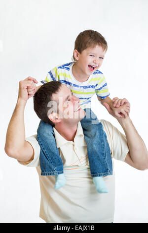 Kid a cavallo del padre di spalle Foto Stock