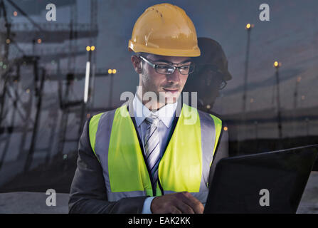 Imprenditore indossando indumenti da lavoro protettiva vicino a finestra Foto Stock