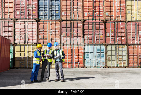 Lavoratore e imprenditori parlando vicino ai contenitori di carico Foto Stock