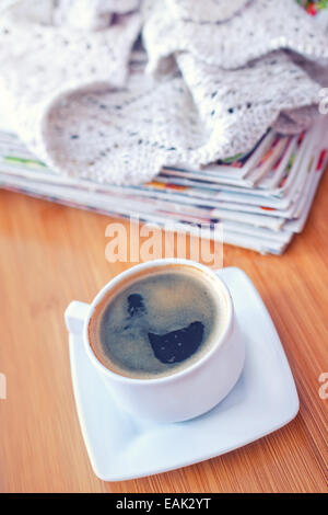 Caffè e la pila di caricatori sul vassoio in legno Foto Stock