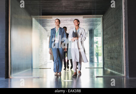Scienziato e imprenditrice camminando in corridoio Foto Stock