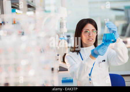 Scienziato esaminando il campione nel becher in laboratorio Foto Stock