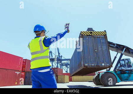 Lavoratore dirigere la gru che trasportano container Foto Stock