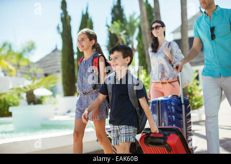 Famiglia con le valigie a piedi verso la località turistica Foto Stock