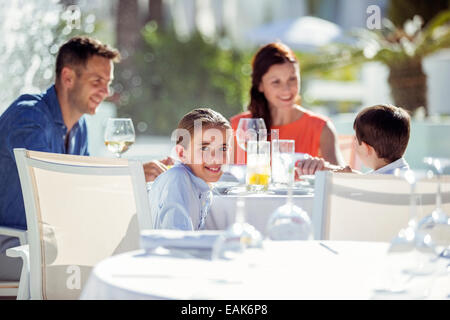 Famiglia con due bambini aventi la cena nel resort all'aperto Foto Stock